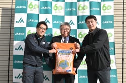 商品化した水稲一発肥料を手にする相馬和揮衛常務理事（左から２番目）