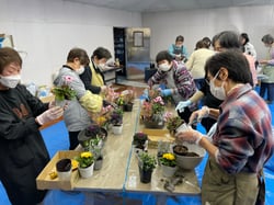 色とりどりの花苗を手に、寄せ植えを楽しむ参加者たち