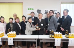 油を寄贈するメンバーとセンター長ら