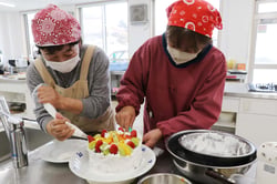 クリスマスケーキのデコレーションを楽しむ大学院生