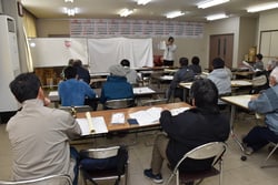 防除暦の変更点を説明する竹内営農技術員（長野県東御市で）