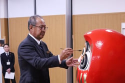 決意を込めてだるまに目入れをする中村組合長
