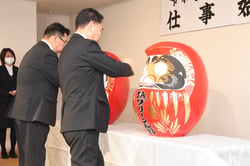 事業目標必達へダルマに目を入れる栗林組合長（右）