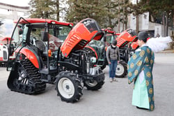 安全を祈願し、おはらいを受ける農機と参列者