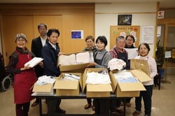 紅林荘で、小林施設長（左から３人目）に清拭布を受け渡す部員・職員