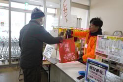 福袋を受け取る来場者㊧