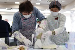 ミートミンサーで大豆の水煮を潰す受講者たち