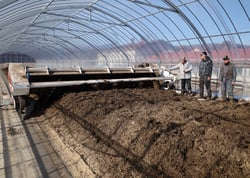 新しい堆肥舎を視察する小平組合長（左）と五味さん家族