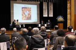 大勢の地域住民が見守る中パネルディスカッションをする新規就農者ら（長野県飯田市で）