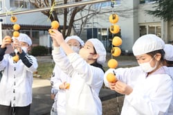 真剣な表情でつるし作業をする児童ら