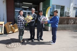 アネモネを手渡す人形部会長（右）とアルストロメリアを手渡す阿部副部会長（左）