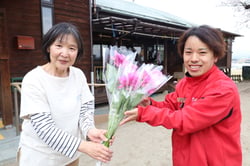 ダリアを贈呈する宮澤所長（右）（長野県飯田市で）