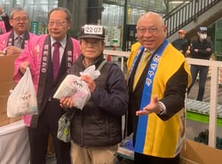 せり人にきのこを手渡す望月組合長（右）と湯本市長（左）