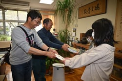 『ちゃぐりん』を手渡す部員ら（左）（１４日、長野県松本市にて）
