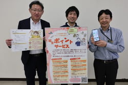 新総合ポイント制度のポスターを手に、登録を呼びかける職員（長野県諏訪市で）