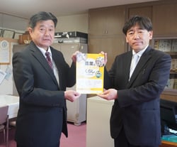 尾臺校長㊨に補助教材を手渡す降籏常務理事（安曇野市豊科）