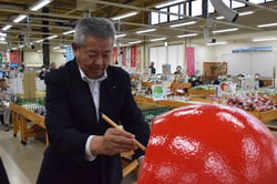 だるまに目を入れる西村組合長（長野県南箕輪村で）