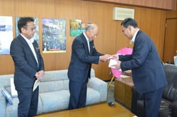 「お米割引券」を受け取る武居町長（右）（長野県辰野町で）