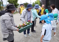 園児たちを思い、色とりどりの花苗をプランターに植える参加者（長野県下諏訪町で）
