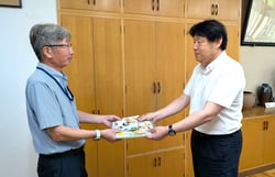 ちゃぐりんとバンダナを手渡す竹下専務（左）と小松校長先生（右）（長野県塩尻市で）