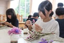 スターチスを生けて「きのぴー」を製作する児童（長野県茅野市で）