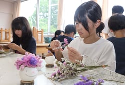 スターチスを生けて「きのぴー」を製作する児童（長野県茅野市で）