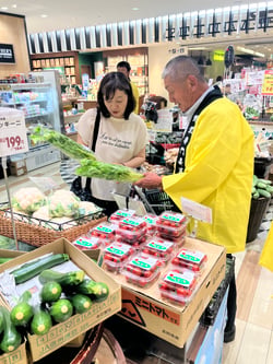 来店客に自慢の高原野菜を売り込む小松委員長（右）（神奈川県横浜市で）