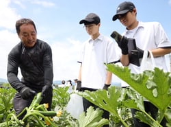 生徒にズッキーニの収穫方法を教える五味さん（左）（長野県茅野市で）