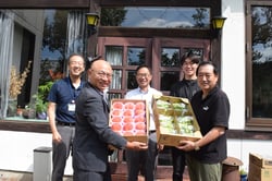 農産物を手渡す望月組合長（左）と小指監督（右）（長野県上田市で）