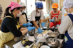 おやきづくりをする教員（７月２８日、佐久市の佐久市立佐久平小学校で）