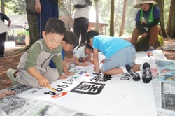 看板に絵をかき込む子どもたち（安曇野市堀金）