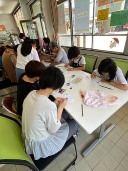 台紙にガラス材を貼り付ける参加者たち（松本市梓川）