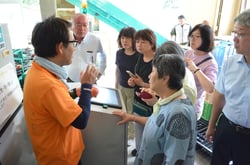 上伊那果実選果場で機械の説明をするＪＡ担当職員（左）（長野県箕輪町で）