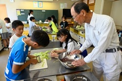 太田会長に教わりながらユウガオを手挽く児童（池田町立会染小学校）