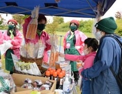 訪れたサポーターに農産物の説明をする女性部員