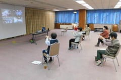 中継映像で講師から手洗いの指導を受ける参加者