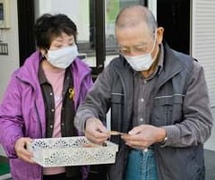 シトラスリボンを手渡す女性部員と受け取る利用者