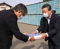 工事の引き渡し証明書を受け取る田中常務