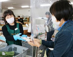 来店客に紅白もちを手渡す従業員