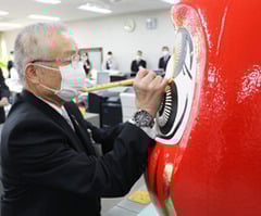 だるまに目を入れる小松組合長