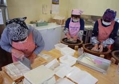 協力してそばを打つ女性部員