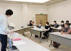 指導係の説明を熱心に聞く受講者