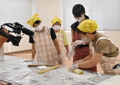 カメラの前で「うずまきかりんとう」づくりに取り組む出演者