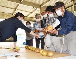 検査された果実を確認する生産者