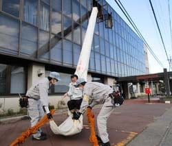救助袋を使った降下訓練で3階から避難する職員（10月21日、上田市中野のモルティしおだで）