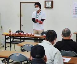 リンゴの出荷規格を説明する営農技術員