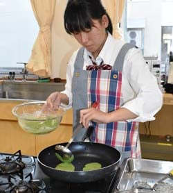 飯山高校の調理室で調理する戸島さん
