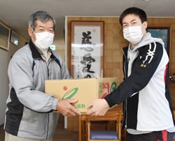 施設の関係者にリンゴを渡す宮崎部会長（左）