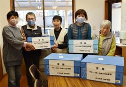 利用者へタオルを手渡すJA女性部山本支部役員（右から2番目：金田支部長）