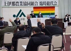 採決にて挙手で賛成を示す出席者ら